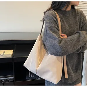 Vue détaillée du grand sac cabas en daim beige porté par un mannequin pour le quotidien