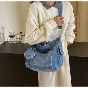 Détail du sac bandoulière en jean bleu avec porte-monnaie rond et boucles métalliques