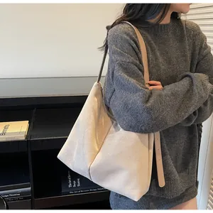 Détails du grand sac cabas en daim beige montrant sa capacité et sa texture douce