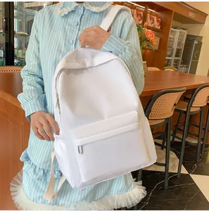 Detailansicht eines weißen Nylon-Rucksacks mit Seitentaschen an einem Model im Café