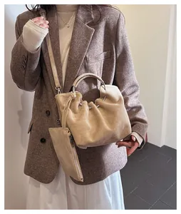 Detail of khaki suede cloud bucket bag with metallic ring handle and a matching mini pouch