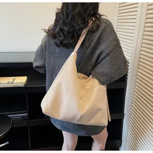Détail du sac cabas en daim crème montrant la texture douce et les finitions de couture