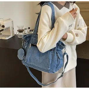 Sac cabas en jean délavé bleu avec poches latérales et une mini pochette ronde chic