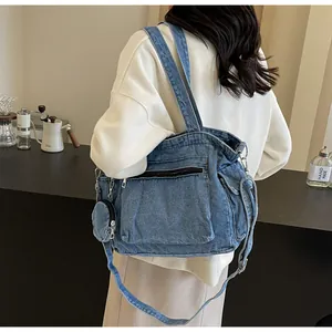 Détail du sac cabas en jean avec petit porte-monnaie assorti et design multipoche