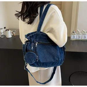 Détail du sac fourre-tout en denim bleu foncé avec poche zippée et petite pochette ronde