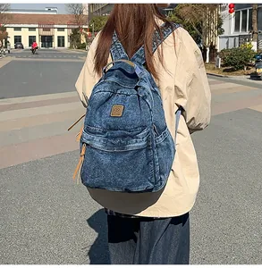 Close-up of vintage denim backpack with leather pullers and front pocket detail