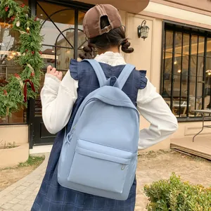 Rückansicht eines hellblauen Nylon-Rucksacks an einem Model in einer Straßenszene
