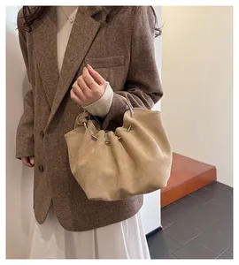 Detail view of khaki pleated cloud bag with large metal ring handle and soft suede texture