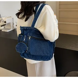 Détail du grand sac cabas en denim bleu foncé avec poche zippée et mini porte-monnaie