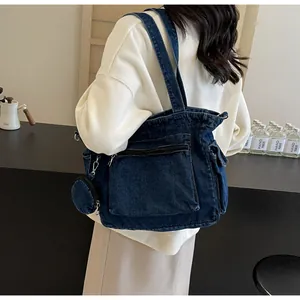 Détail du grand sac cabas en denim bleu avec poche zippée et petit porte-monnaie rond