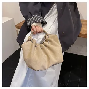 Detail of khaki pleated cloud bag showing suede texture and silver metal ring handles