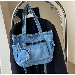 Dettaglio della borsa tote in denim azzurro con tasca a zip e portamonete tondo