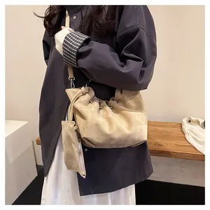 Detail of beige suede cloud bag with drawstring pleats and silver ring handle