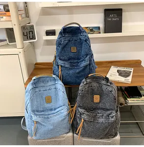 Detailed view of large denim backpacks in deep blue light blue and grey tones
