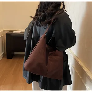 Détail du grand sac cabas en daim marron foncé avec coutures raffinées et poche latérale