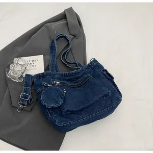 Detailed macro view of dark blue denim tote bag with silver zippers and mini coin purse