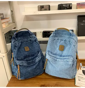 Close-up of high-quality denim texture and leather zipper pull on backpack