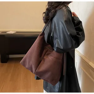 Détail du sac cabas en daim marron foncé avec bandoulière réglable et fermeture éclair
