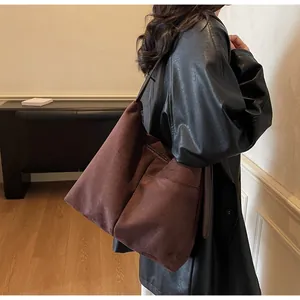 Vue détaillée du grand sac cabas avec poches avant et texture en daim mat élégante