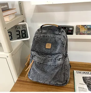 Detailed shot of retro washed denim backpack with vintage leather zipper pull accents