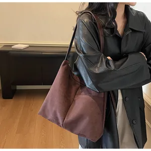 Détail du grand sac cabas en daim marron avec texture mate et poche latérale pratique