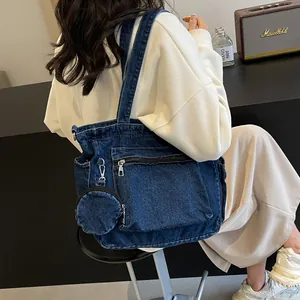 Grand sac cabas en denim bleu foncé avec poches et petit porte-monnaie sur un mannequin