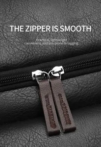 Close-up of smooth dual metal zippers with brown leather pullers on black PU leather bag