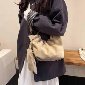 Minimalist beige pleated cloud shoulder bag with mini pouch worn by a model