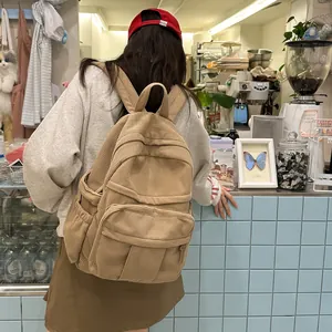 Detail der Textur des khakifarbenen Cord-Rucksacks und der Seitentasche im Café