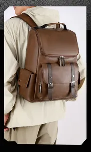Detail view of brown vintage PU leather backpack with metallic buckle straps on a model