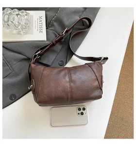 Detail view of the retro dark brown leather handbag featuring sleek vertical stitching