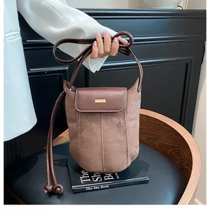 Close-up of brown suede and smooth leather stitching detail on luxury crossbody bag