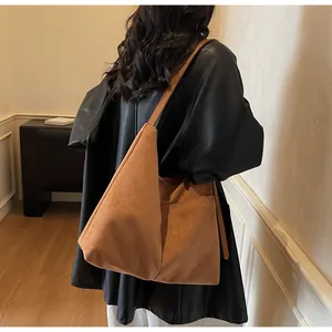 Vue détaillée d'un grand sac cabas marron en daim avec une poche latérale pratique