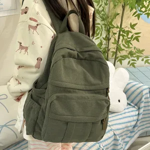 Detailansicht des dunkelgrünen Cord-Rucksacks mit weicher Textur und Seitentaschendesign