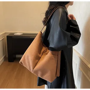 Grand sac cabas en daim marron porté épaule avec silhouette souple et style chic
