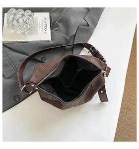 Interior view of brown PU shoulder bag featuring black fabric lining and a zipper pocket