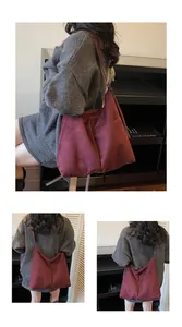 Détail du sac cabas en daim bordeaux montrant la texture douce et la couture latérale