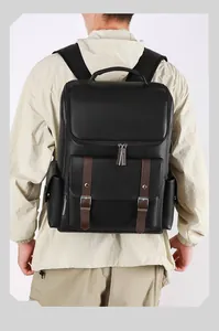 Close-up of black PU leather backpack with vintage brown straps and metal buckles