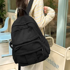 Detailansicht eines schwarzen Cord-Rucksacks mit mehreren Taschen und weicher Textur am Modell