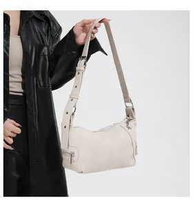 Detail of off-white hobo bag showing pebbled texture and star-shaped metal zipper pull