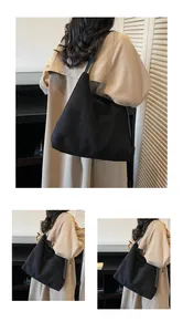 Détail du grand sac cabas noir mat minimaliste montrant la texture suédée et l'espace