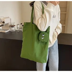 Détail macro du sac fourre-tout vert en toile avec pendentif brodé en forme de grand œil