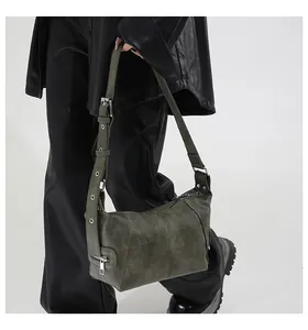 Close-up of olive green crossbody bag featuring textured faux leather and eyelet strap