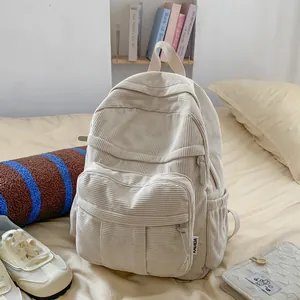 Nahaufnahme der Textur des cremefarbenen Cord-Rucksacks mit Details der Seitentasche