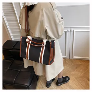 Detailansicht der großen schwarzen Segeltuchtasche mit Lederriemen und weißen Akzenten