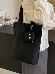 Sac cabas pliable monstre noir en nylon avec motif yeux et mini pochette zippée assortie