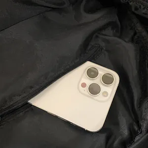 Black denim backpack interior showing a large zipper pocket fitting a large smartphone