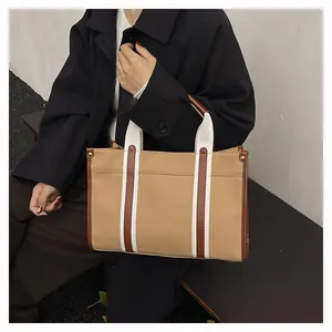 Khaki Canvas-Shopper mit braunem Lederbesatz und goldenen Nietendetails aus der Nähe