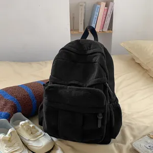 Detaillierte Textur des schwarzen Cord-Rucksacks mit Vordertasche im gemütlichen Zimmer