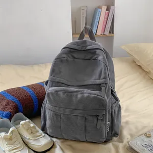 Detailansicht des grauen Cord-Rucksacks mit großer Fronttasche und praktischen Seitentaschen